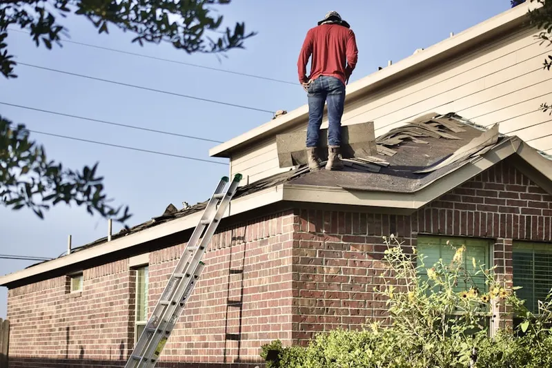 Professional roofer working on a residential roof in Davison